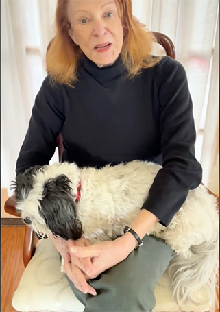 Janet sitting with a shaggy dog on he lap.
